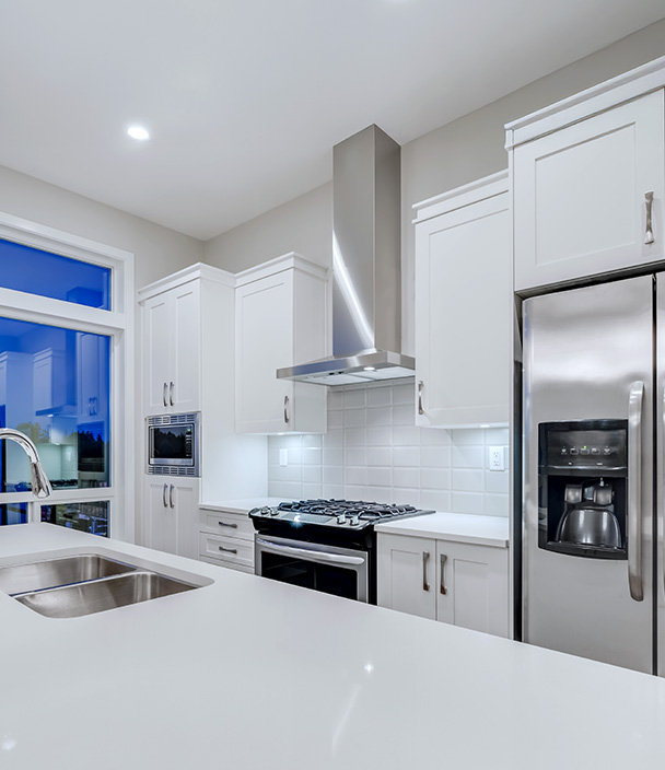 A modern kitchen with white shaker cabinets and stainless steel appliances